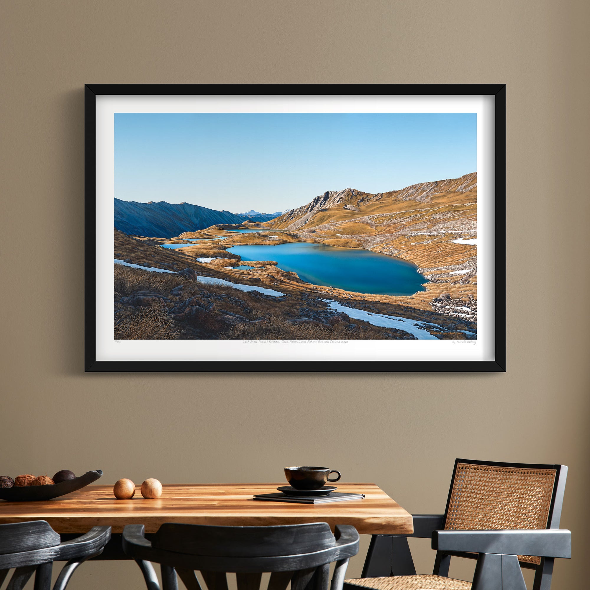 Fine art print of the Paratītahi Tarns in Nelson Lakes National Park, featuring serene backcountry scenery with tarns and rugged mountains, painted by Michelle Bellamy. Pictured in dining room in a black frame.
